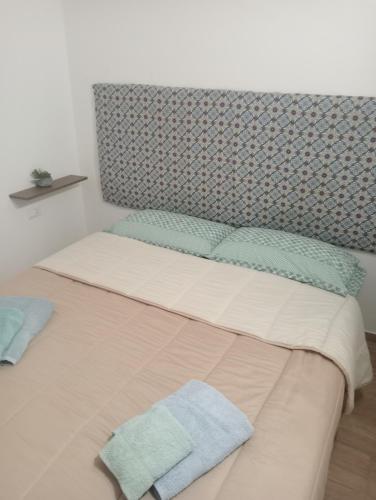 a bed with two towels sitting on top of it at Il Fico d`India in Ispica