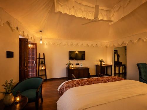a bedroom with a large bed and a tv at Jawai Garh Resort in Bīsalpur