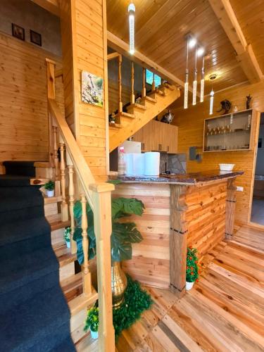 a kitchen in a log cabin with a staircase at SymphonyA in Gorists'ikhe