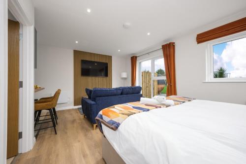 a bedroom with a large bed and a blue couch at Cherry Lodge by Escape Ordinary in Coleraine