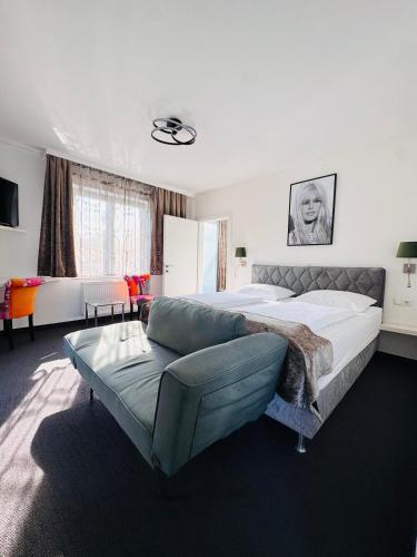 a large bedroom with a bed and a couch at Boutique Hotel OASE, mit oder ohne Frühstück buchbar, Parkplatz kostenlos in Bad Ischl