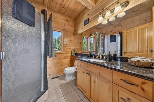 a log cabin bathroom with a shower and a toilet at Mountain View Log Home in Invermere in Invermere
