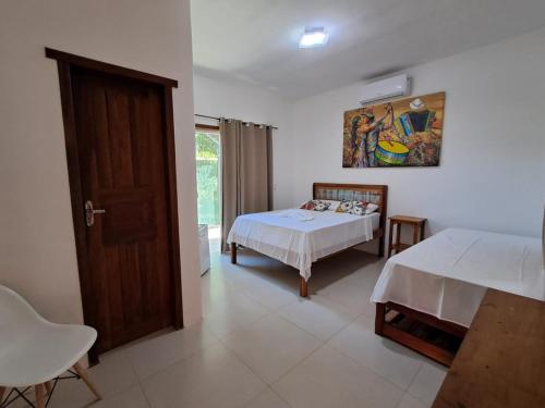 a bedroom with two beds and a window at Pousada Mirante de Areia-Itaúnas in Itaúnas