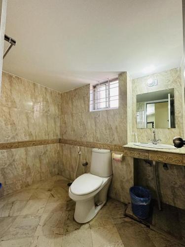 a bathroom with a toilet and a sink at Suite Sadaf in Cox's Bazar
