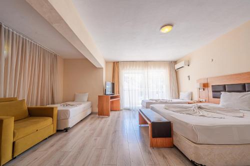 a hotel room with two beds and a chair at Begonville Hotel in Marmaris