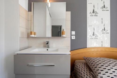 a bathroom with a white sink and a mirror at Maison familiale Morgat, proche mer in Crozon
