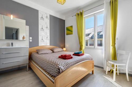 a bedroom with a bed with two red towels on it at Maison familiale Morgat, proche mer in Crozon