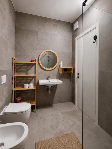 a bathroom with a sink and a toilet and a mirror at Emera Apartments in Vlorë