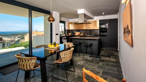 a kitchen and dining room with a table and chairs at Luxury villa Mar with infinity pool in Rab in Palit