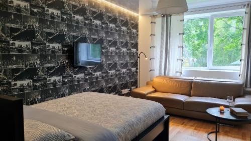 a living room with a couch and a tv at Teodor Apartment in Budraičiai