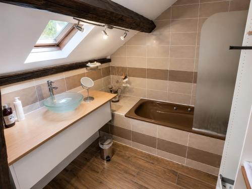 a bathroom with a sink and a bath tub at Hotel du Golf de Clécy in Clécy