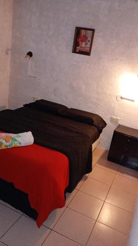 a bedroom with a bed with a red blanket at Valdez Resi in Santa Rosa