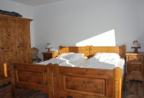 a large wooden bed with white sheets and pillows at Haus Nautic Whg 809 Seesicht in Cuxhaven