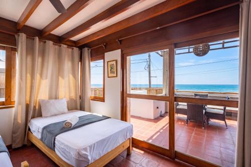 a bedroom with a bed and a view of the ocean at El Templo Surf House in Punta Hermosa