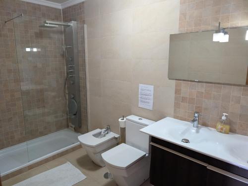 a bathroom with a toilet and a sink and a shower at Loreto Luxury in Arco da Calheta