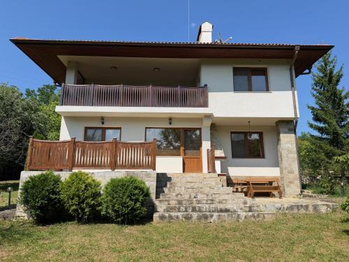 a house with a porch and a wooden fence at The Old Walnut House in Terziysko