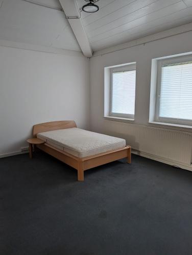 a bedroom with a bed in a room with two windows at IBB Ferien- Monteurwohnung 3 Schlafzimmer 3 Betten in Ibbenbüren