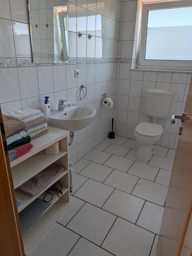 a white bathroom with a sink and a toilet at IBB Ferien- Monteurwohnung 3 Schlafzimmer 3 Betten in Ibbenbüren