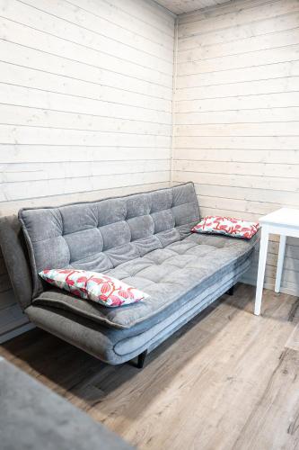a gray couch with pillows sitting in a room at Mērsraga namiņš in Mērsrags