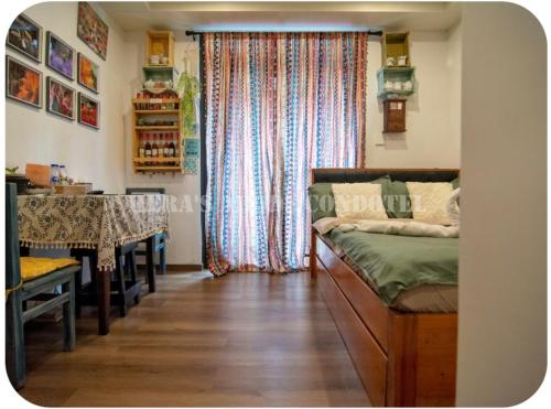 a bedroom with a bed and a table and a window at Megatower 4 Diorite Unit in Baguio