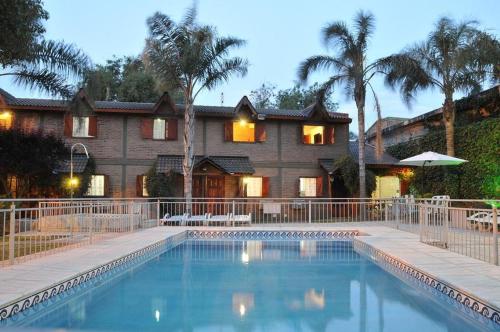 a house with a swimming pool in front of a house at Cabañas Nazareth in Villa Carlos Paz