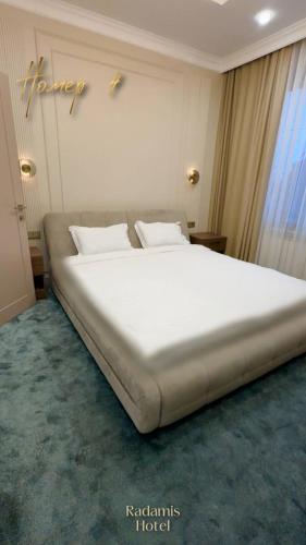 a large white bed in a room with a window at Radamis in Almaty