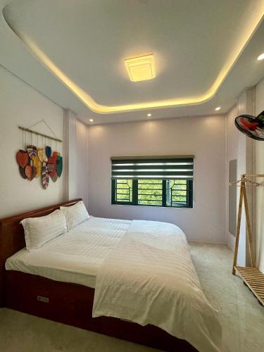 a bedroom with a large bed and a window at Quỳnh s House in Tân Hiệp