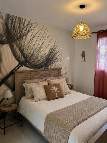 a bedroom with a large bed and a chandelier at TI kasa cherry in Le Diamant