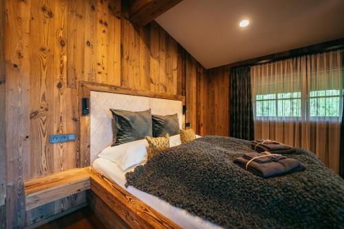 a bedroom with a bed in a wooden wall at Alpin Chic by Alpe Chalets in Unterseefeld