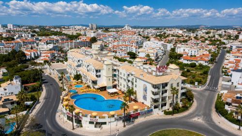 an aerial view of a city with a building and a pool at Grand Muthu Forte do Vale in Albufeira
