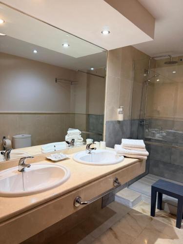 a bathroom with two sinks and a large mirror at Hotel Sierra Hidalga in Ronda