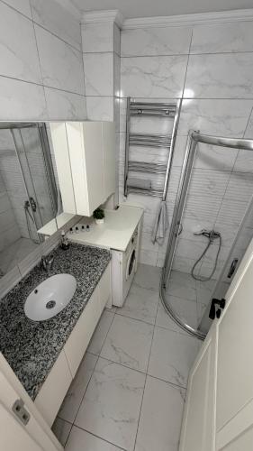 a white bathroom with a sink and a shower at Galfa House in Bostancı