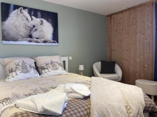 a bedroom with a bed and a picture of wolves at Spacious flat facing Mont Blanc in Combloux
