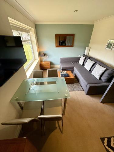 a living room with a couch and a table at Bagshaw Lodge in Bakewell