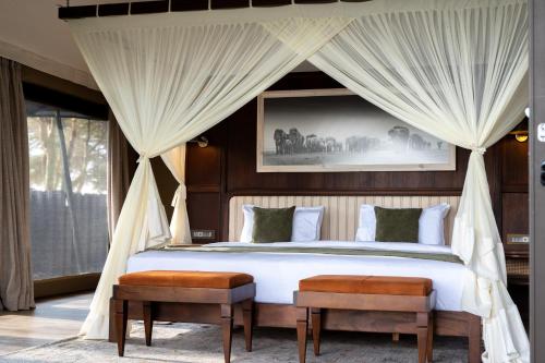 a bedroom with a bed with a canopy at Soroi Amboseli in Amboseli