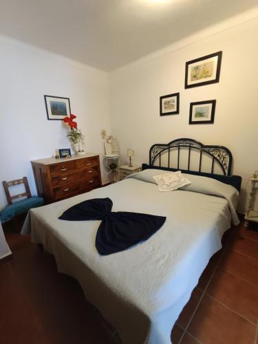 a bedroom with a bed with two robes on it at Casa Benlindha in Degolados
