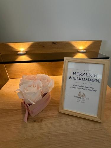 a bouquet of white roses sitting next to a framed picture at Inselquartier Ratzeburg in Ratzeburg