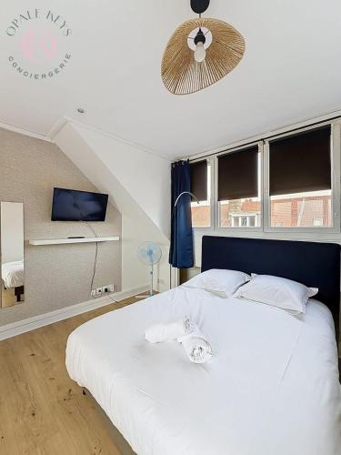 a bedroom with a large white bed and windows at Le Studio Bleu - Dernier etage & Confort in Coudekerque-Branche