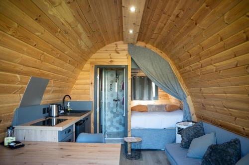 a room with a bed and a kitchen with a sink at Lodge des Bois Jacuzzi in Target