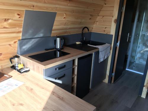 a kitchen in a tiny house with a sink at Lodge des Bois Jacuzzi in Target