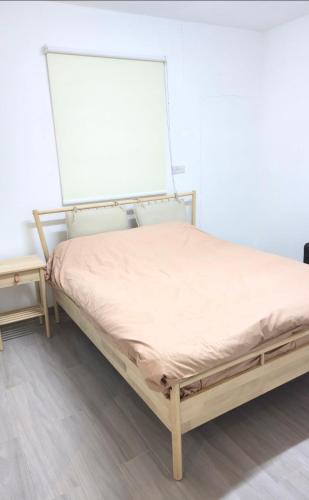 a bed in a room with a white wall at Azure liwa in An Nashshāsh