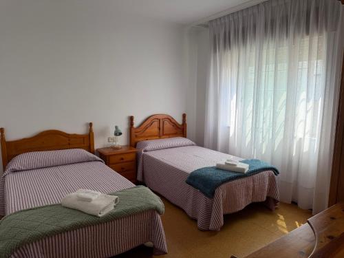a bedroom with two twin beds and a window at Piso Super Espacioso en Cambados Centro in Cambados