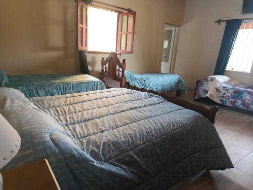 a bedroom with two beds and a window at Cabaña MariaMaria in Pomancillo