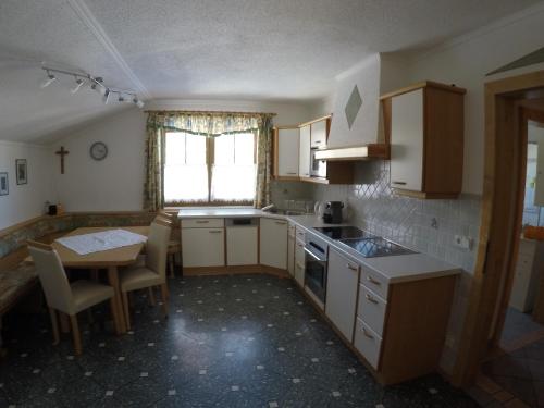 kuchnia ze stołem, zlewem, stołem i krzesłami w obiekcie Ferienwohnung GIA w mieście Haus im Ennstal