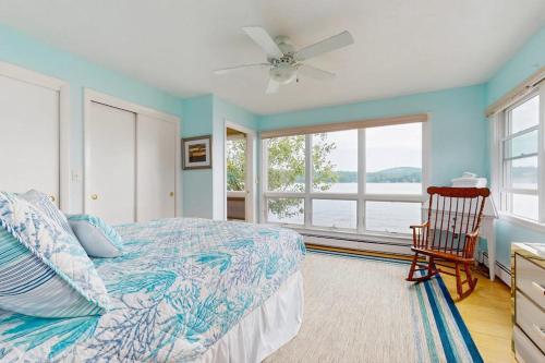 ein Schlafzimmer mit einem Bett, einem Stuhl und einem Fenster in der Unterkunft Loon Watch in Alton Bay