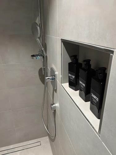 a bathroom with a shower with black boxes in a niche at Moderne Studio Oase in Donaueschingen