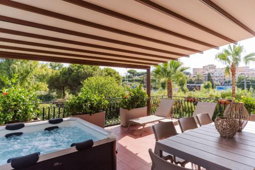 a patio with a hot tub and a table and chairs at Villa Domina by Letstay in Giardini Naxos