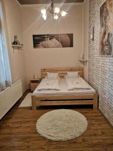 a bedroom with a bed and a white rug at Levander Apartmenthouses in Makó