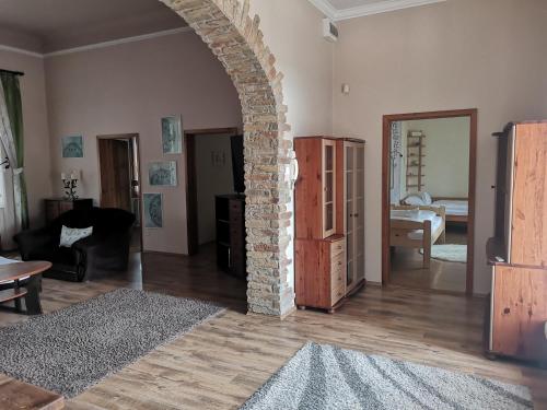 a living room with a brick archway and a room with a bedroom at Levander Apartmenthouses in Makó