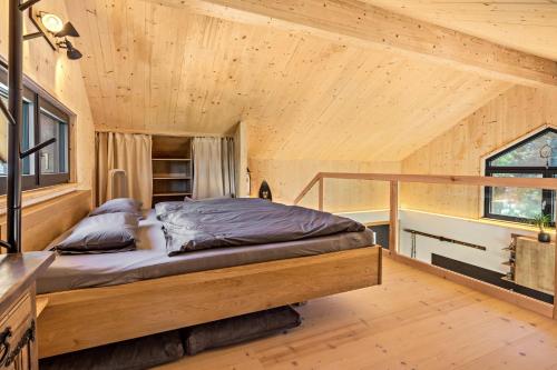a bed in a room with a wooden ceiling at Tiny House in Pischelsdorf am Engelbach